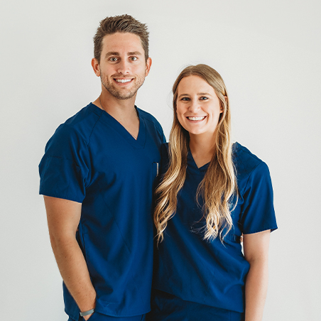 Two Grenada dentists in dark blue scrubs