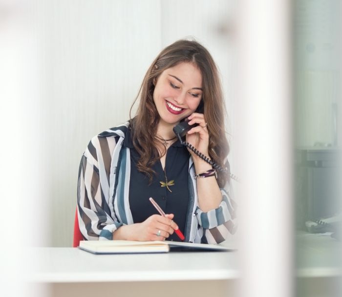 Woman smiling while talking on phone with Grenada dental office