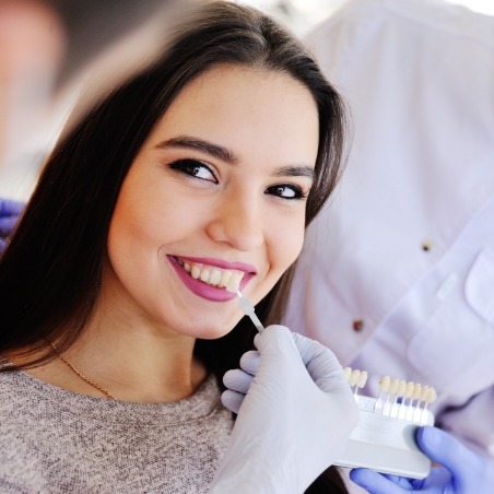 Young woman in dental chair being fitted for veneers