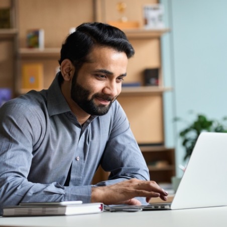 Man sitting at desk and using laptop