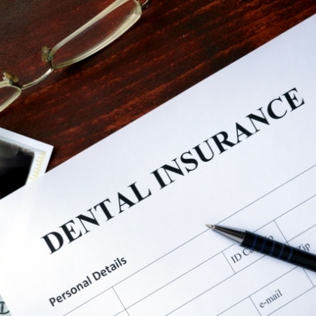 Dental insurance paperwork on wooden desk