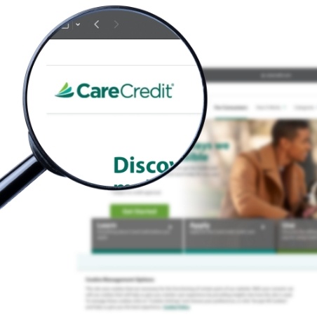 Magnifying glass showing Care Credit logo on their website