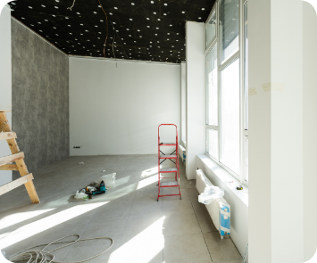 White hallway with ladders and electrical wiring being worked on