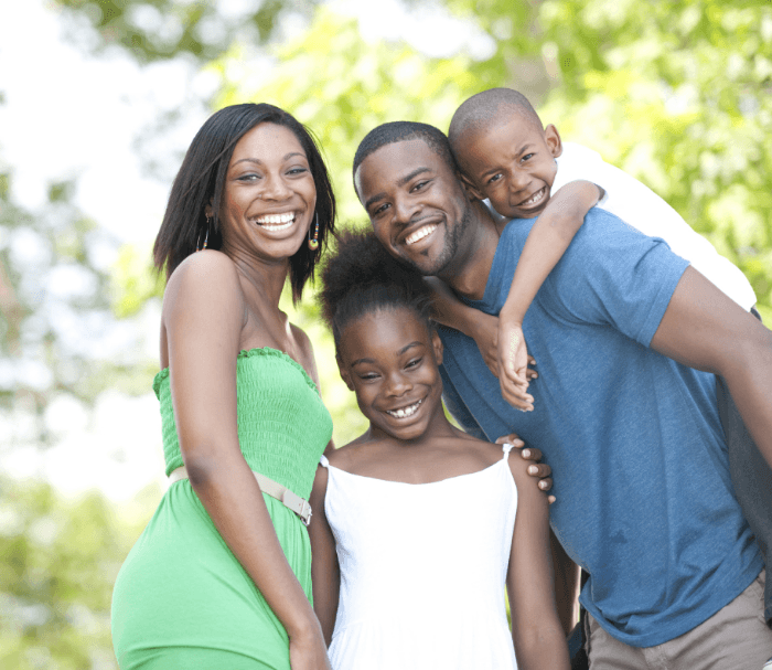 Family of four smiling outdoors