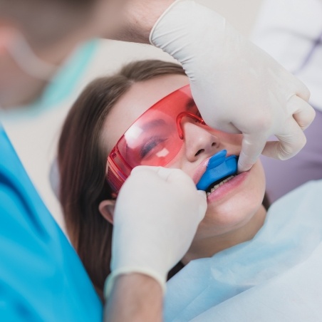 Dental patient having fluoride applied to her teeth