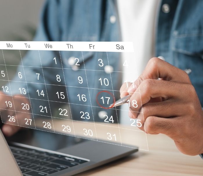 Person circling the date of their dental appointment on a calendar