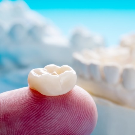 Dental crown resting on a finger