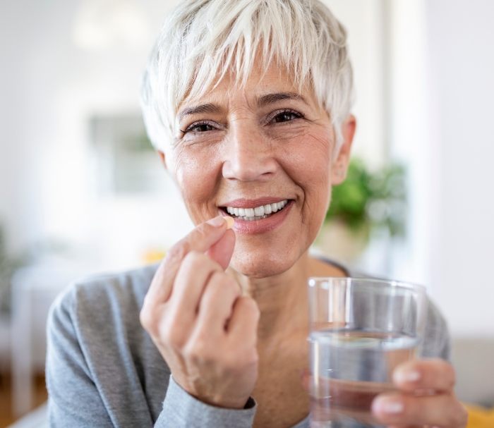 Senior woman taking a pill for sedation dentistry in Grenada