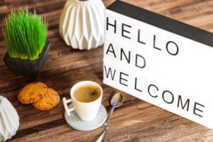 “Hello and welcome” sign next to cup of coffee