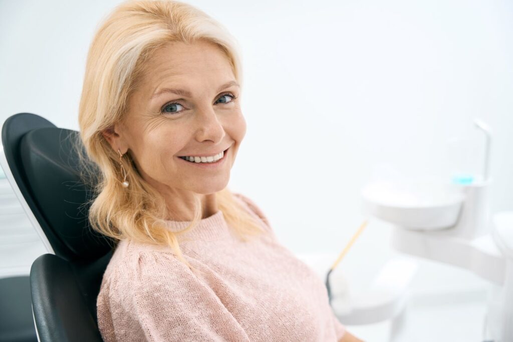 A woman smiling in a dentist's chair.